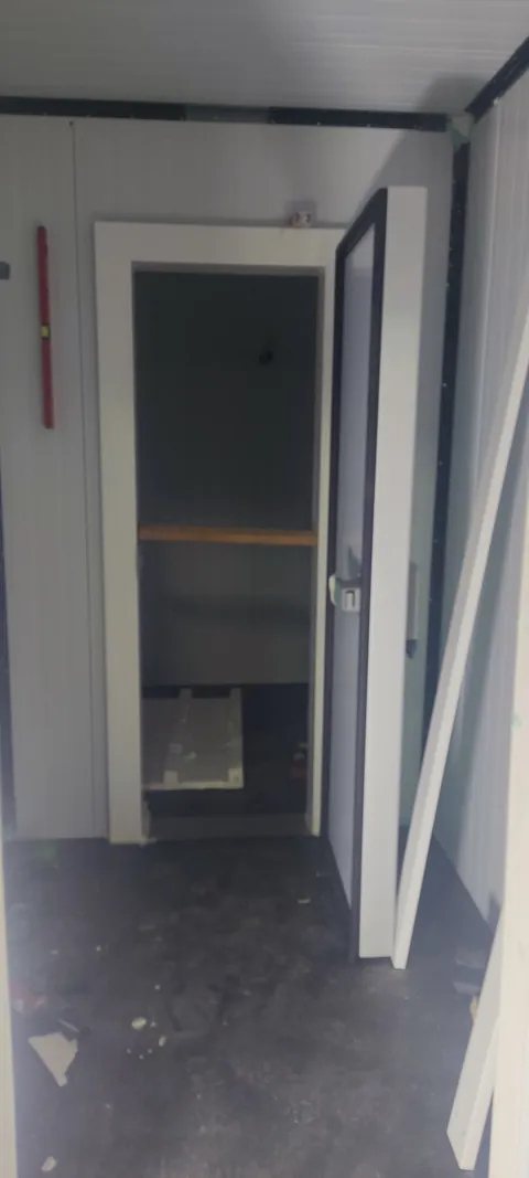 Puerta técnica de una cámara climatizada de vino construida en un garaje, vista desde el exterior
