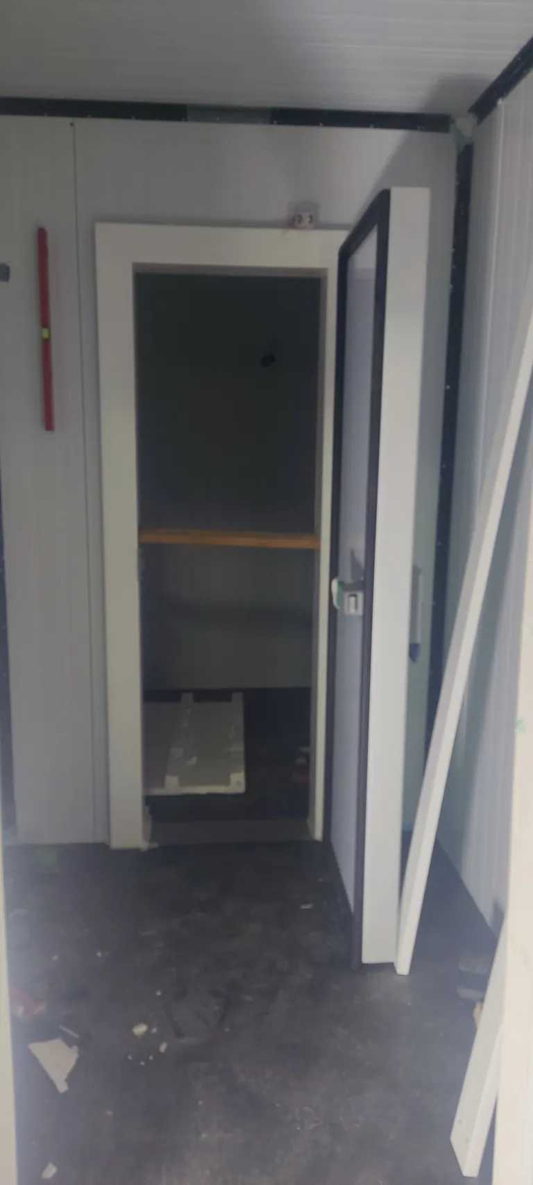 Puerta técnica de una cámara climatizada de vino construida en un garaje, vista desde el exterior