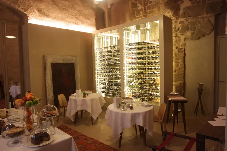 Cava expositora de tres metros con frente de cristal y botellas dispuestas en horizontal sobre botelleros metálicos